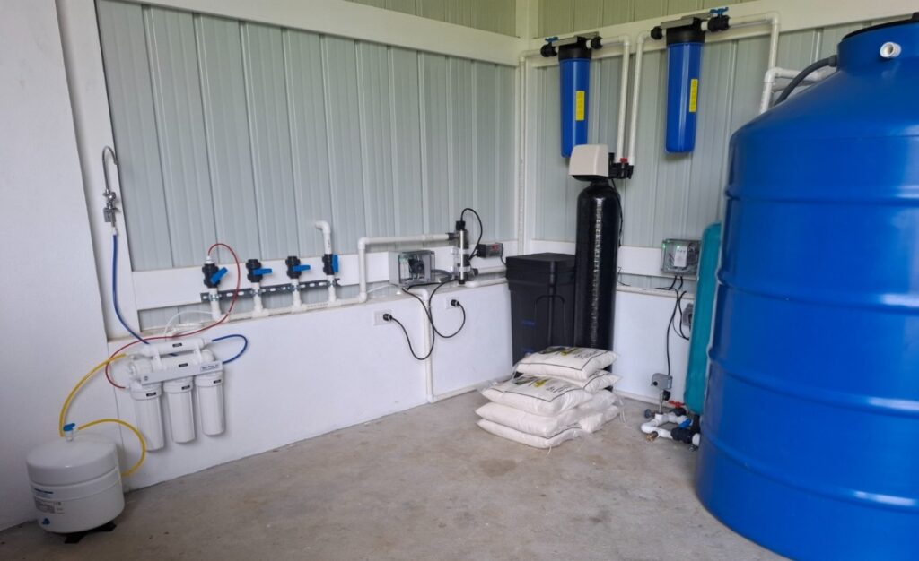 Sala de equipos con ablandador, filtro de carbón, sistema de ósmosis inversa y tanque de presión sobre piso seco.
