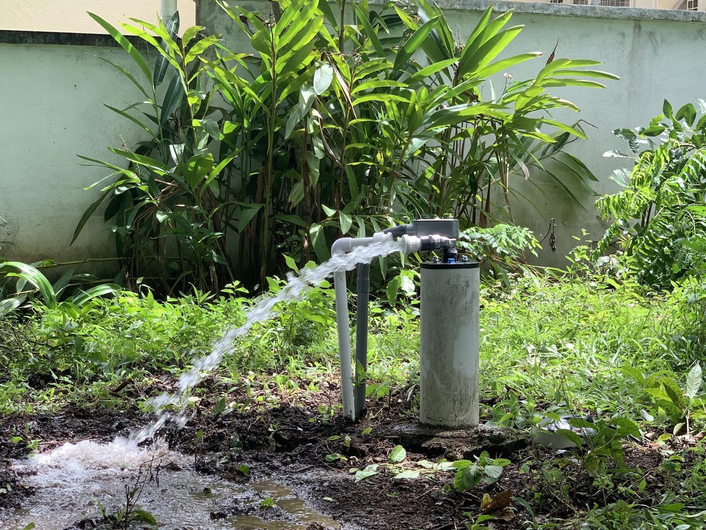 Pozo nuevo en prueba de flujo, agua saliendo junto al encamisado