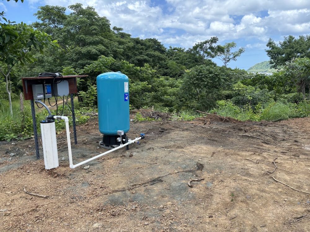 Tanque de presión y controles de bomba en una propiedad junto al bosque