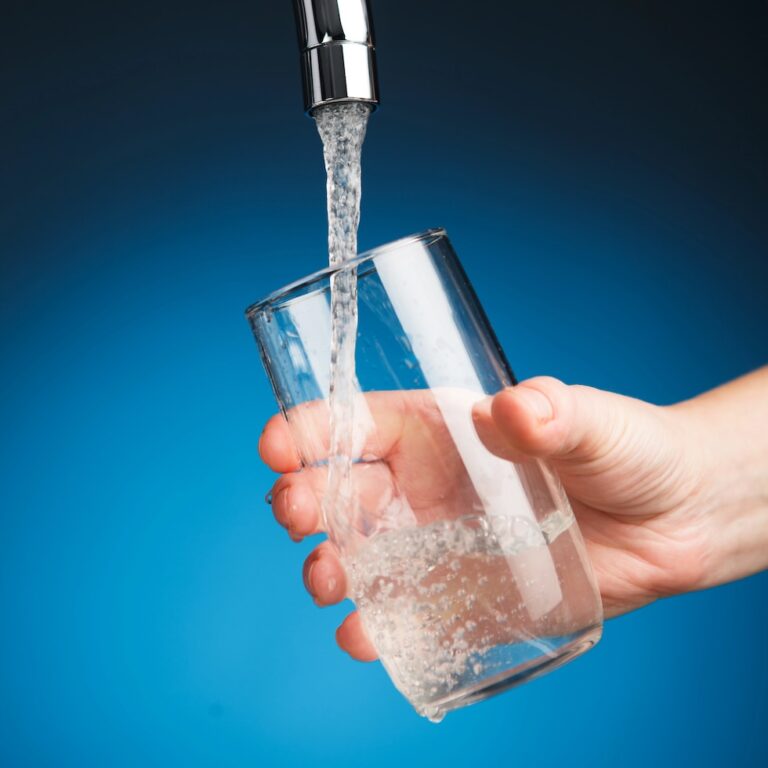 hand pouring a glass of water from filter tap